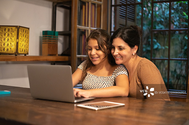 母亲在家辅导女儿做作业图片素材