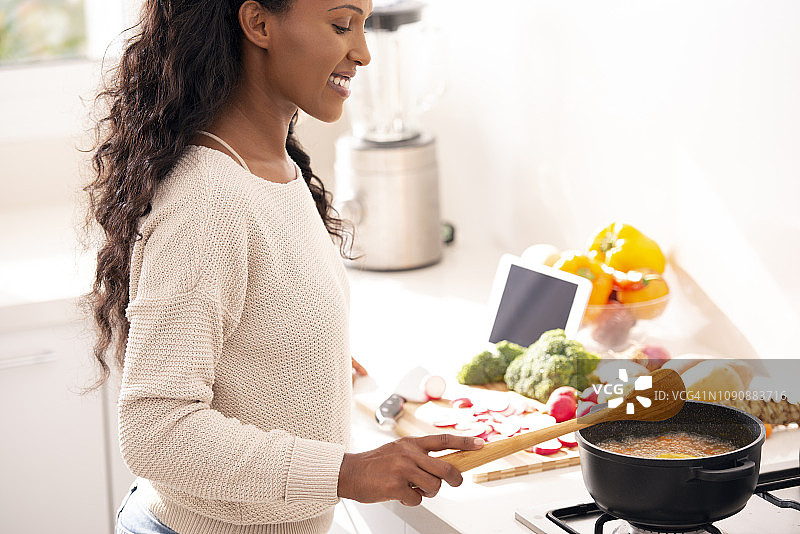 家庭主妇用木勺搅拌汤图片素材