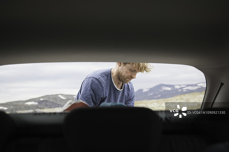 成熟男子在挪威Oppland从汽车中卸货的车头盖视角图片素材