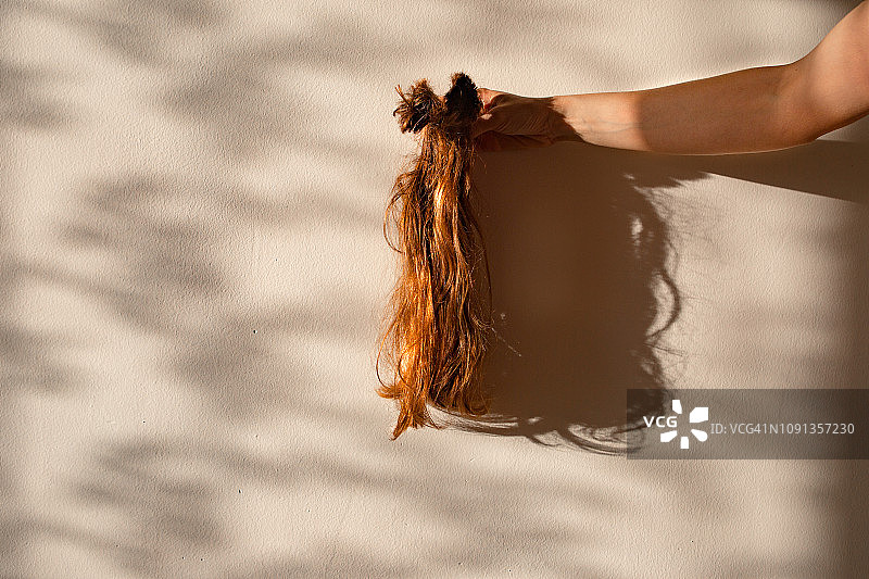 女人手中拿着剪下来的头发图片素材