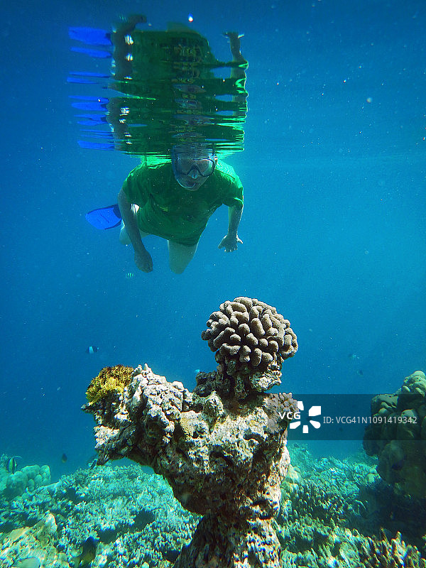 在马尔代夫泻湖中身穿绿色T恤的年长男人图片素材