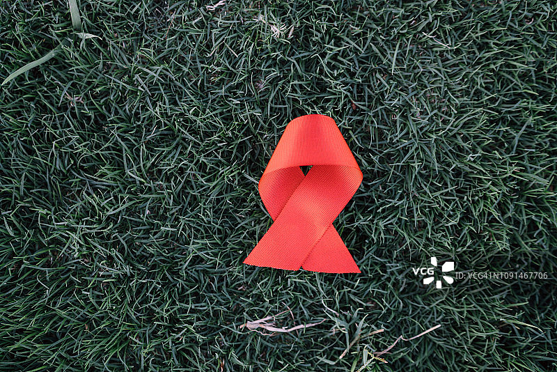 世界艾滋病日：绿草地上的红色丝带图片素材