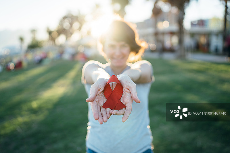佩戴红色艾滋病意识丝带的年轻女子图片素材
