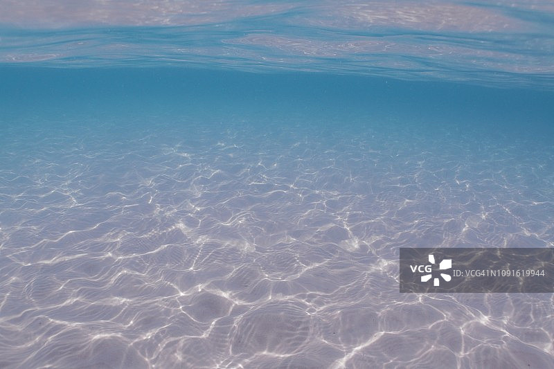 阳光下的沙质海底和水面图片素材