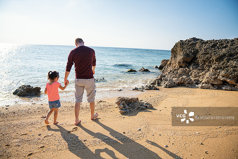 父女手牵手在海滩散步图片素材