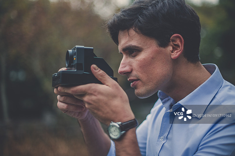 用宝丽来相机拍照的英俊男人图片素材