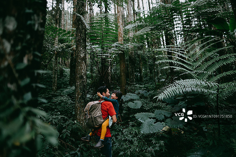 父亲和学龄前女儿在丛林中享受亲密时光图片素材