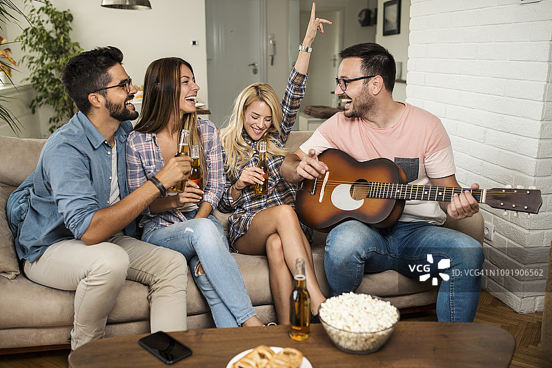 一起玩音乐、喝啤酒的快乐年轻人图片素材