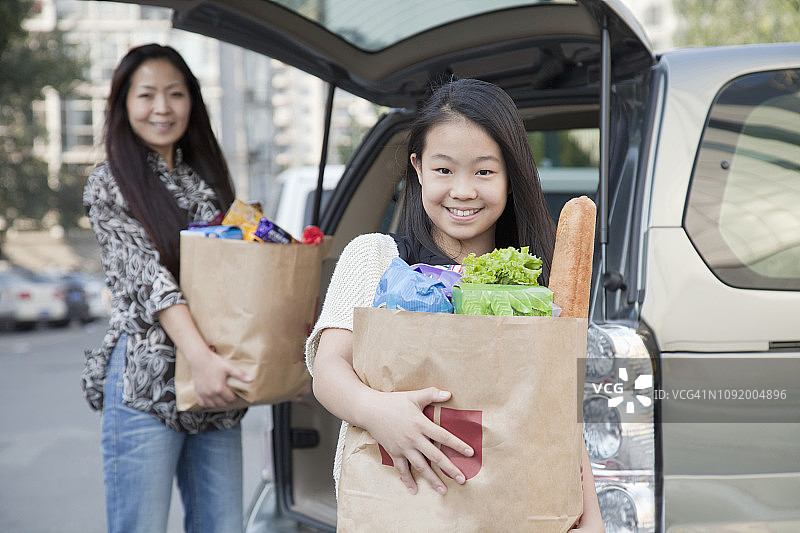 中国母女从车上卸下食品杂货图片素材