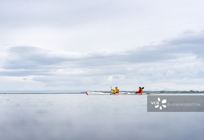 朋友们在平静的湖面上划皮划艇图片素材