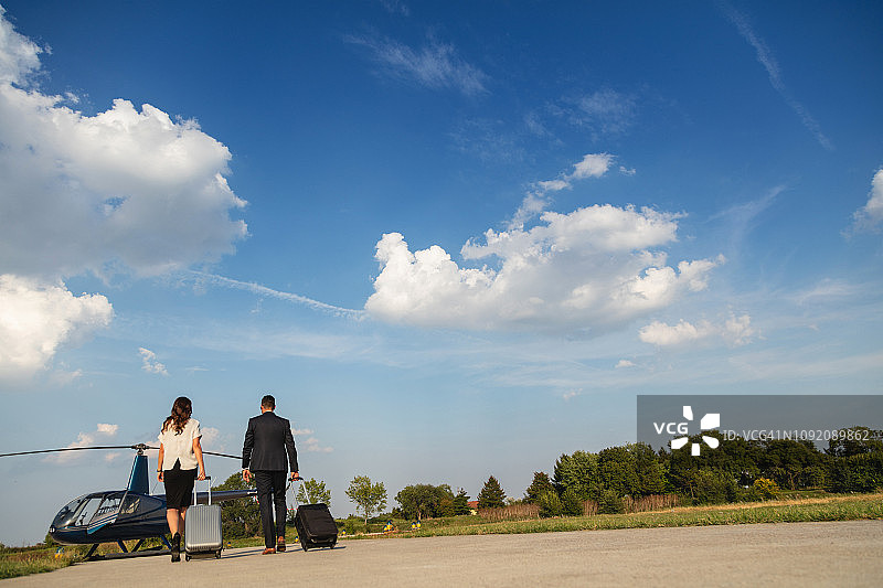 两位商人携带行李走向直升机图片素材