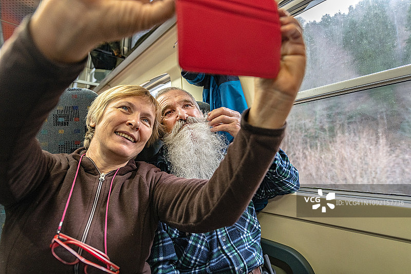 年长的朋友们在冬天乘坐火车旅行，欧洲图片素材