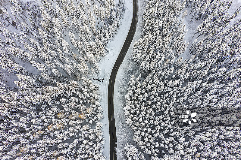 无人机：冬季森林雪地中的空中公路之旅图片素材