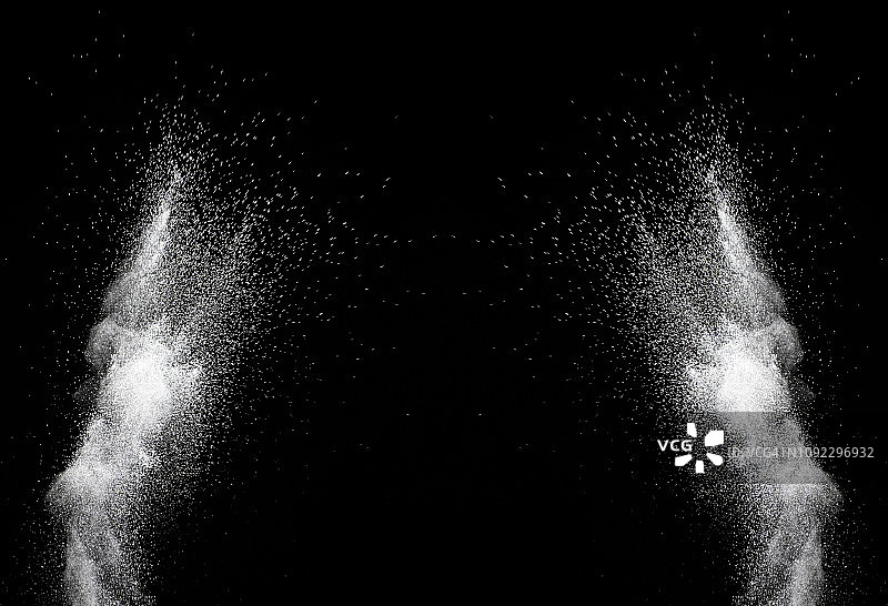白色粉末粒子云在黑色背景上的冲击爆炸图片素材