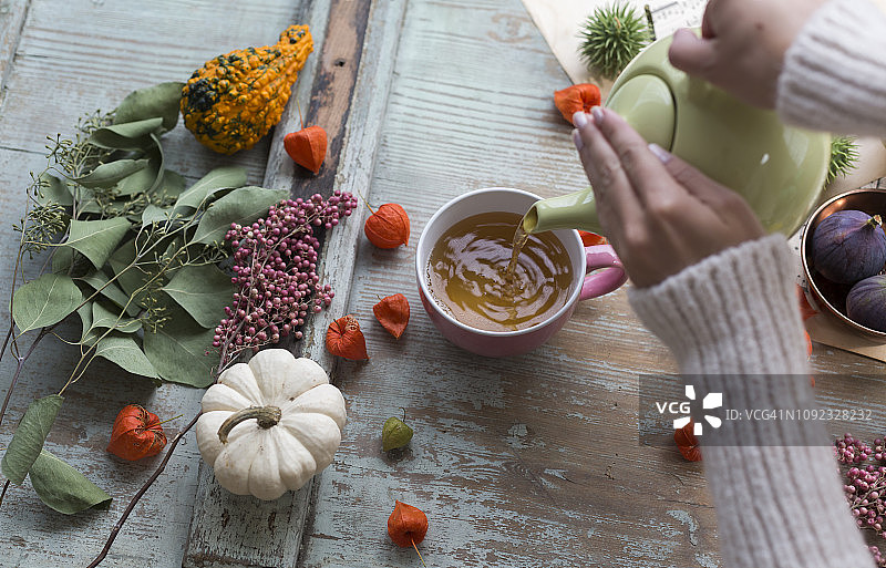 女人往杯子里倒茶图片素材