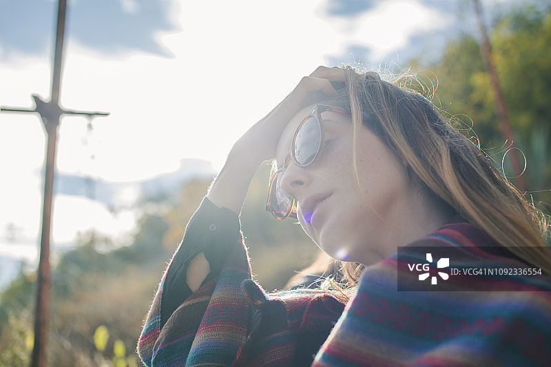 戴着太阳镜徒步旅行的年轻女人图片素材