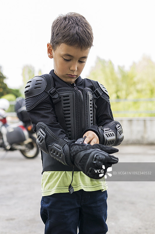 准备摩托车旅行的男孩穿上防护服图片素材
