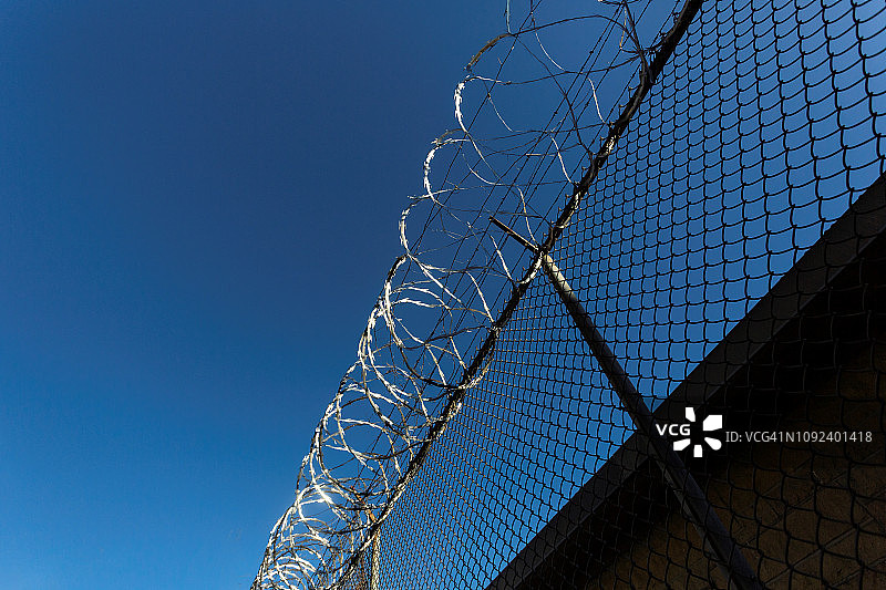 监狱围墙和带刺铁丝网图片素材