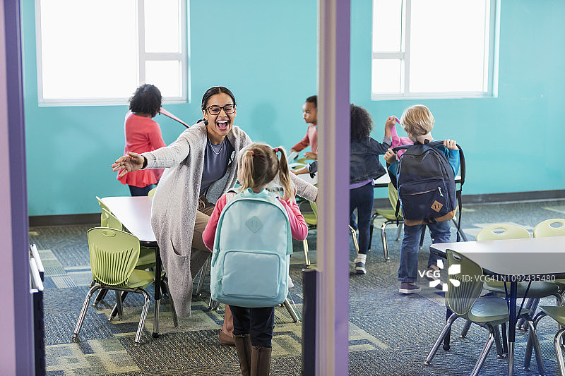 教室里的幼儿园老师迎接学生图片素材