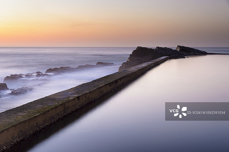 南非夸祖鲁-纳塔尔海岸汤普森湾潮汐池（岩石池）和海滩的黎明图片素材