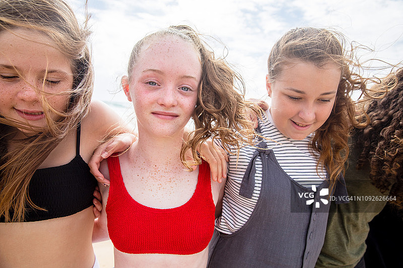 在澳大利亚海滩上玩耍、奔跑和交谈的青少年朋友图片素材