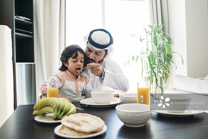 阿拉伯男人和儿子在家中共进早餐图片素材