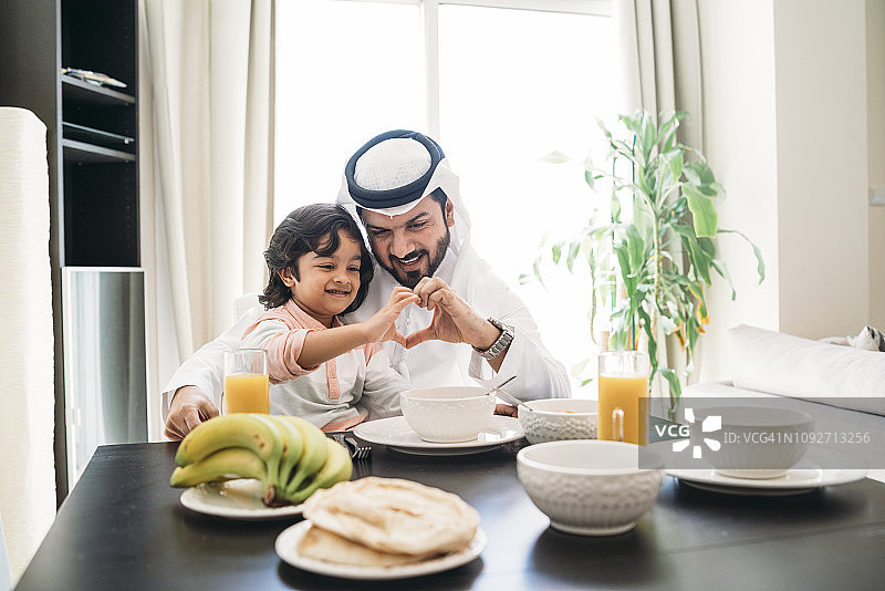 阿拉伯男人和儿子在家中共进早餐图片素材