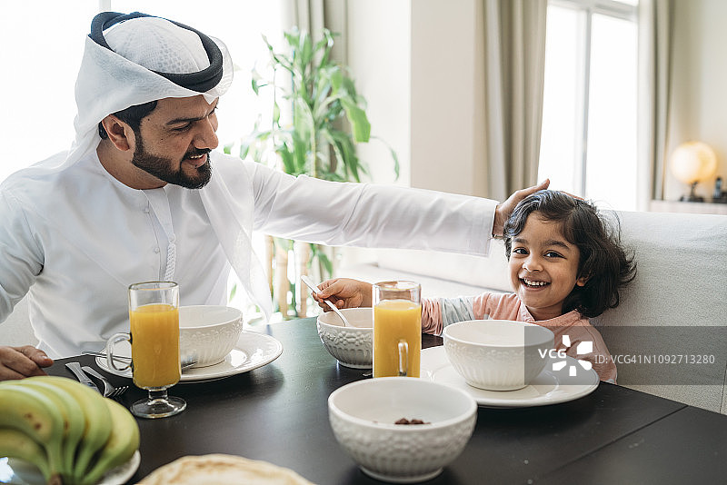 阿拉伯男人和儿子在家中共进早餐图片素材