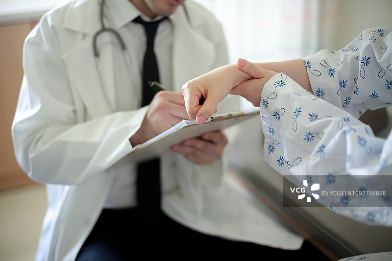 医生检查病人手腕疼痛图片素材