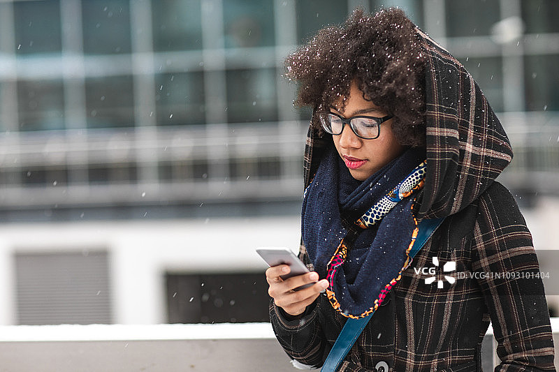 在户外使用智能手机的年轻女子图片素材