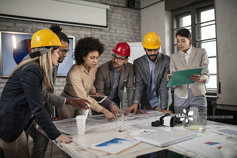 在办公室会议上合作检查蓝图的建筑师图片素材