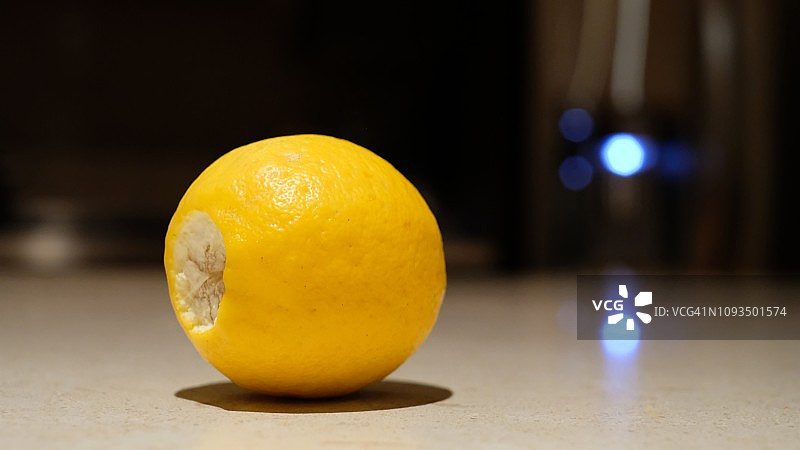 厨房台面上的黄色柠檬与冰箱蓝光反射图片素材