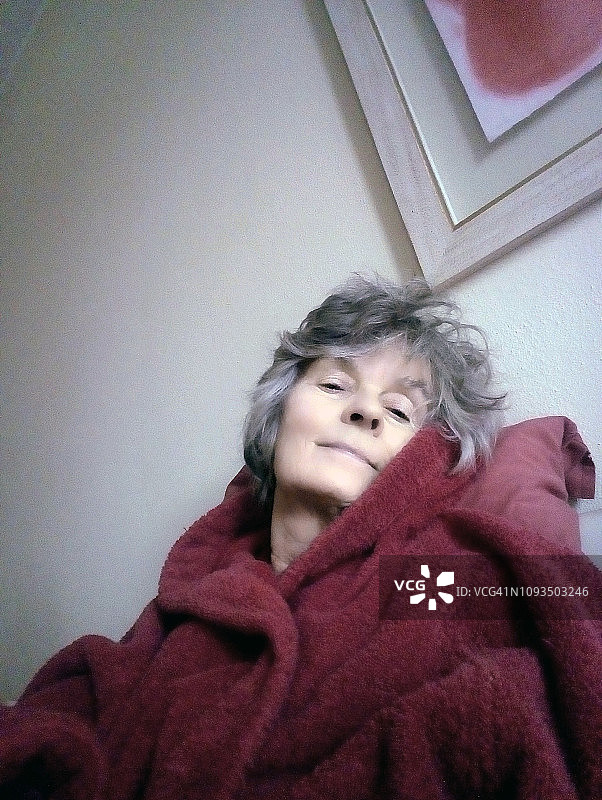 身穿紫色浴袍的微笑老年妇女图片素材