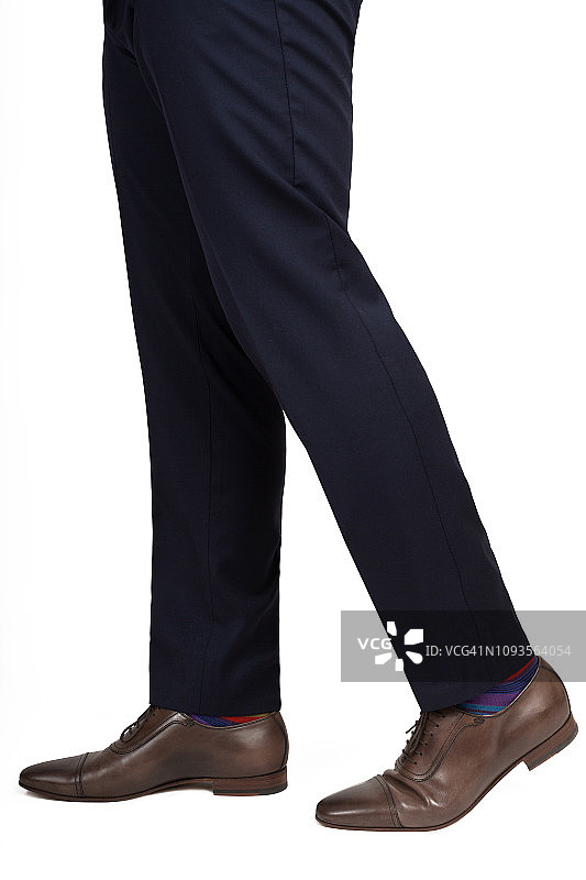 特写：男人行走姿势的鞋子和裤子，白色背景图片素材