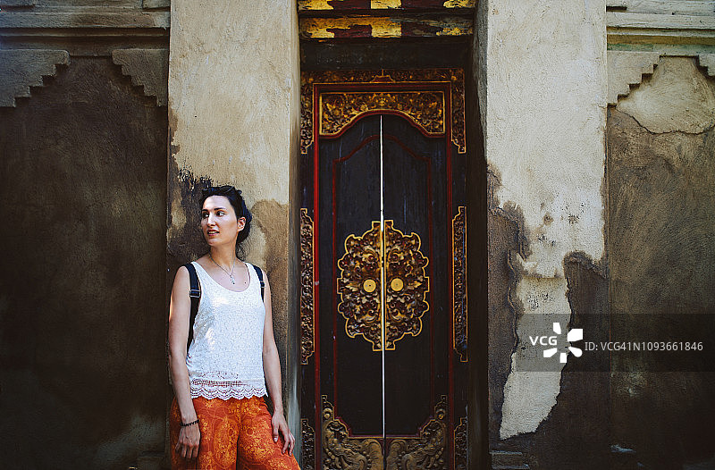 年轻女游客在巴厘岛寺庙旁放松身心图片素材