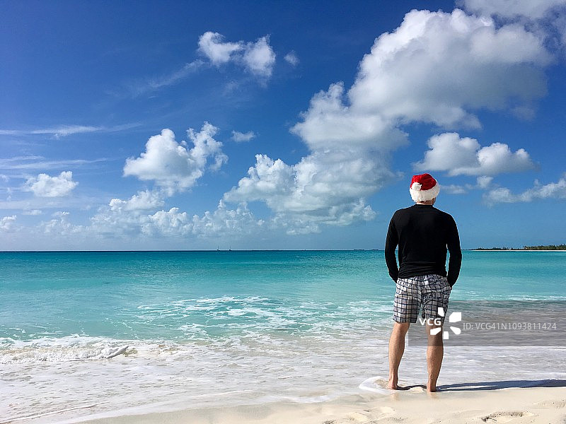 戴着圣诞帽的男人看着加勒比海图片素材