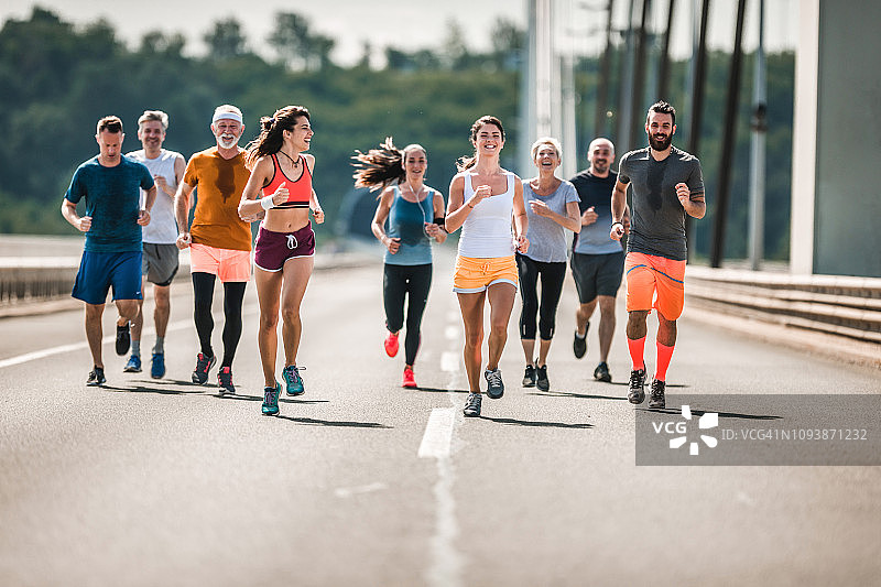 一群快乐的运动员在道路上参加马拉松比赛图片素材