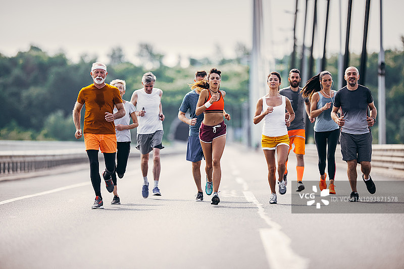 一大群不同年龄的马拉松运动员在路上图片素材