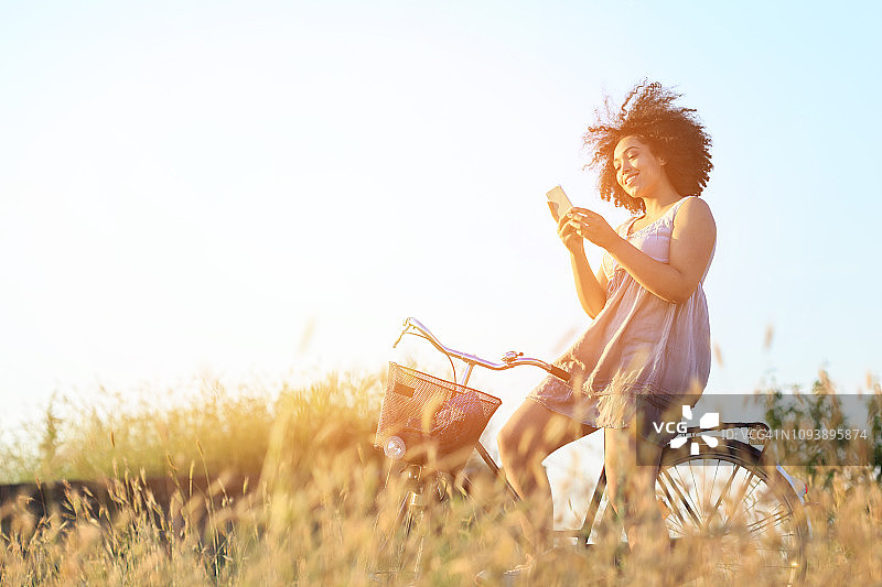 用智能手机骑自行车的女人图片素材