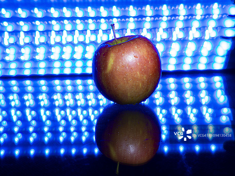 现代蓝色背景下带水滴的苹果图片素材