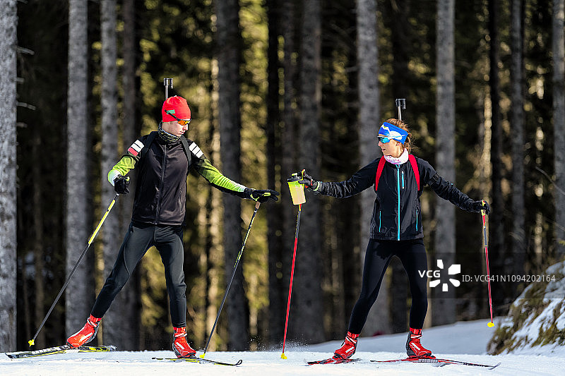 在冬季两项训练期间给同事递饮料的年轻女性图片素材