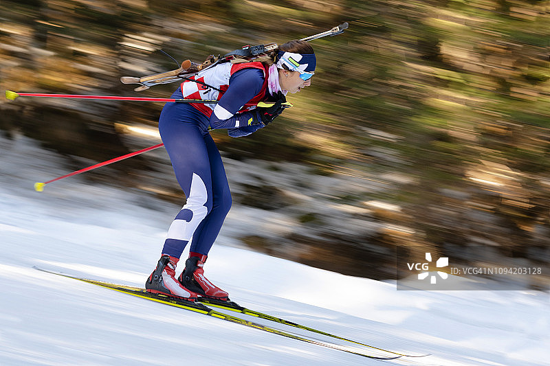 越野滑雪的女子冬季两项运动员侧视图，动态模糊图片素材