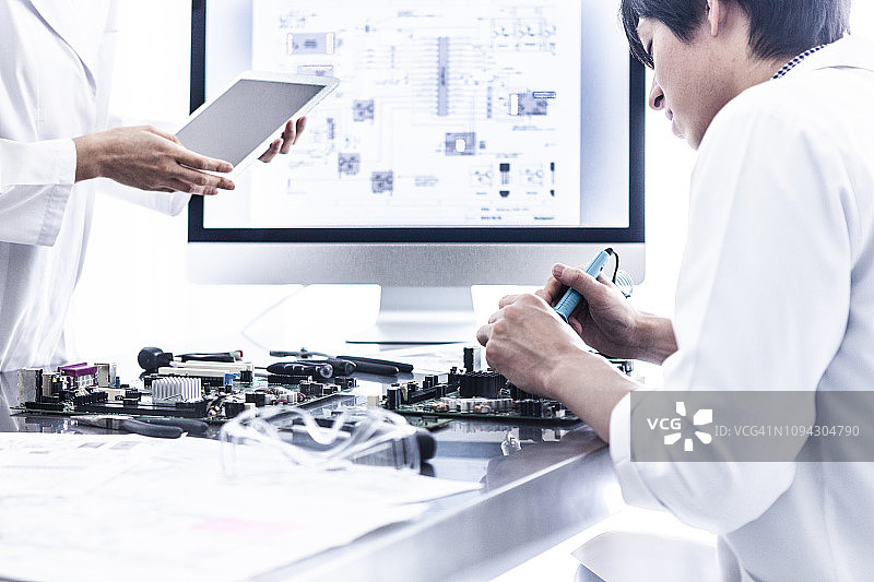 科学家用平板电脑和个人电脑检查工作流程图片素材