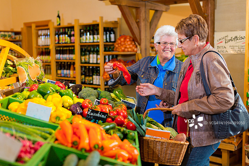两位年长的女性顾客在保健食品店购买新鲜蔬菜图片素材
