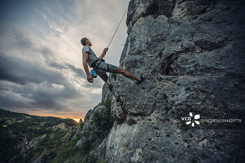 攀登岩石山的残疾男子图片素材