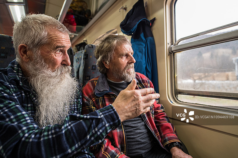 年长朋友们在冬天乘火车旅行时交谈图片素材