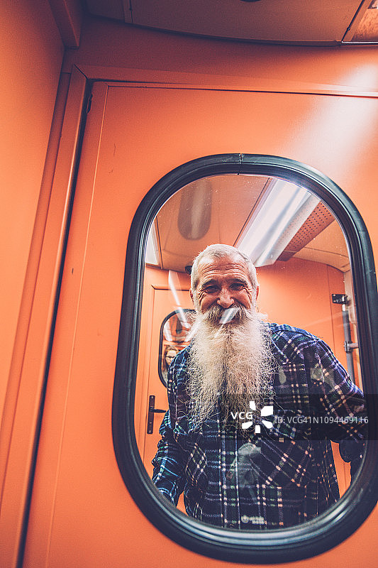 在橙色火车上的一位年长男人图片素材