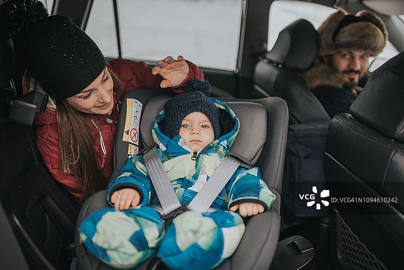 一对年轻夫妇带着孩子，关注安全驾驶图片素材