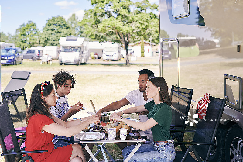 一家人在拖车公园的露营车外餐桌旁享用美食图片素材