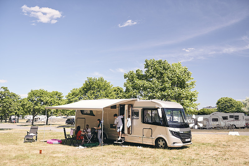 在露营地旅行拖车外的家庭露营图片素材